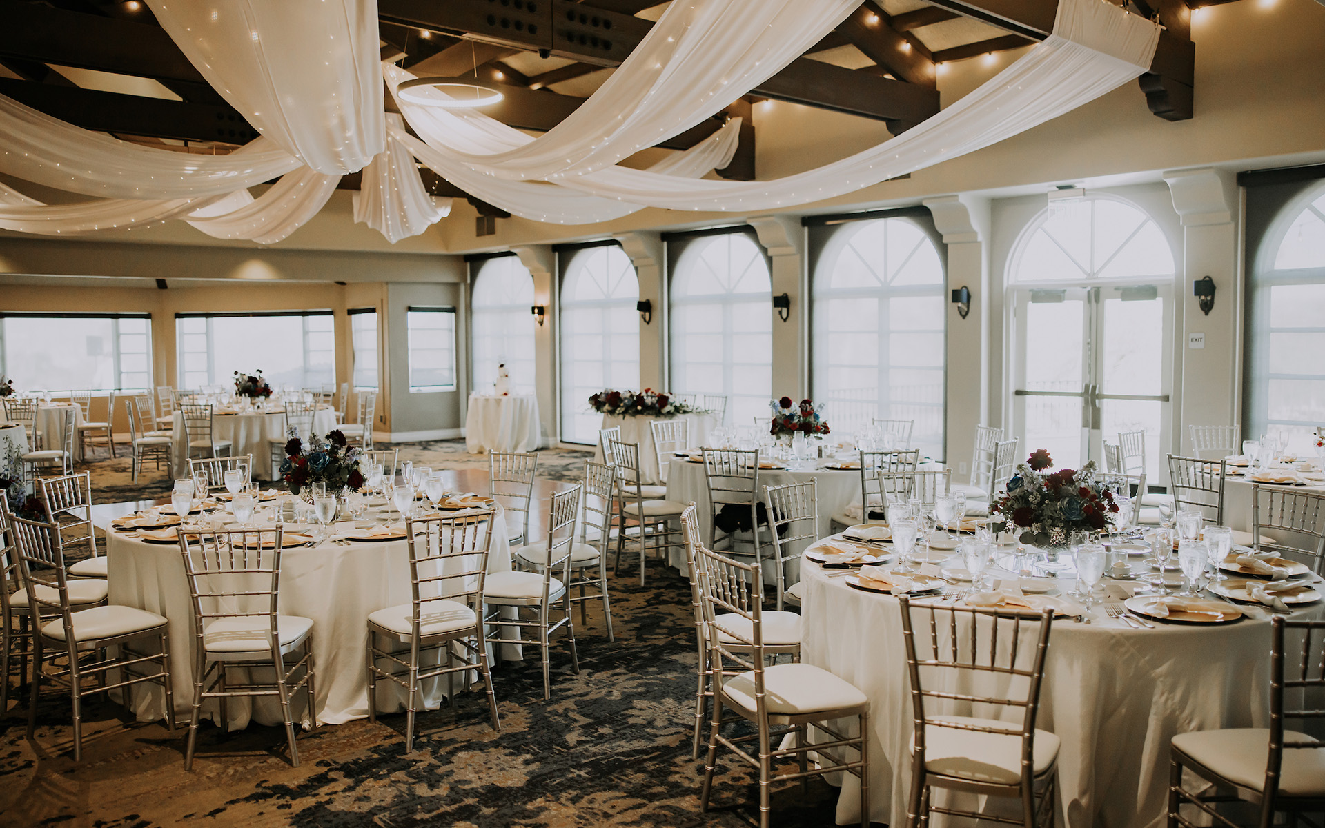 Event space set up with tables and chairs for a wedding